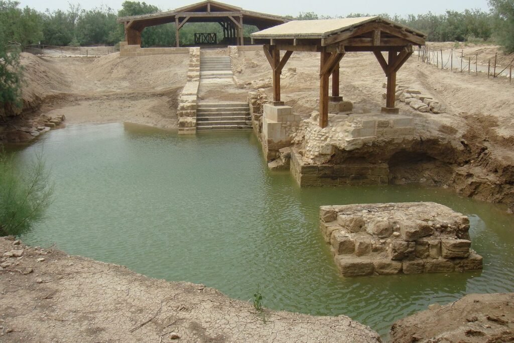 Pool with stone steps and wooden roofs at the baptism site on the Jordan