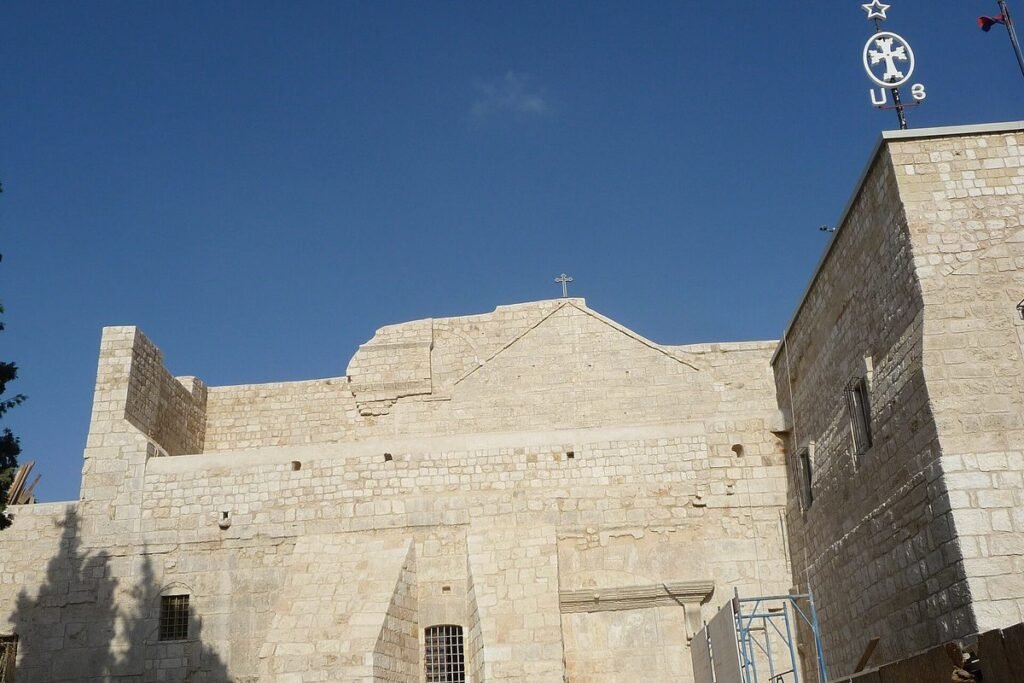 Light stone walls of the Church of the Nativity against a blue sky