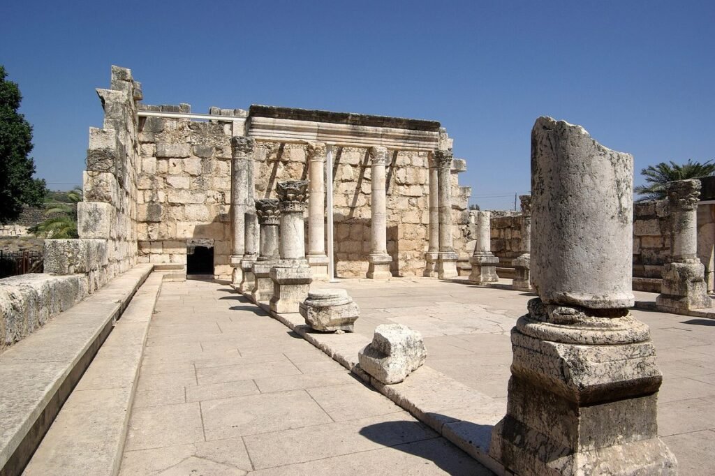 Columns and walls of the pale limestone synagogue ruins at Capernaum