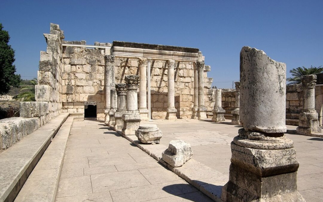 Columns and walls of the pale limestone synagogue ruins at Capernaum