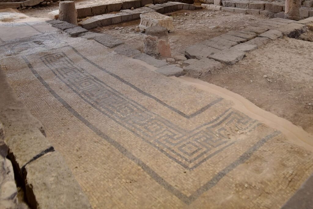 Uncovered stone floor with a mosaic band in the ancient synagogue at Magdala
