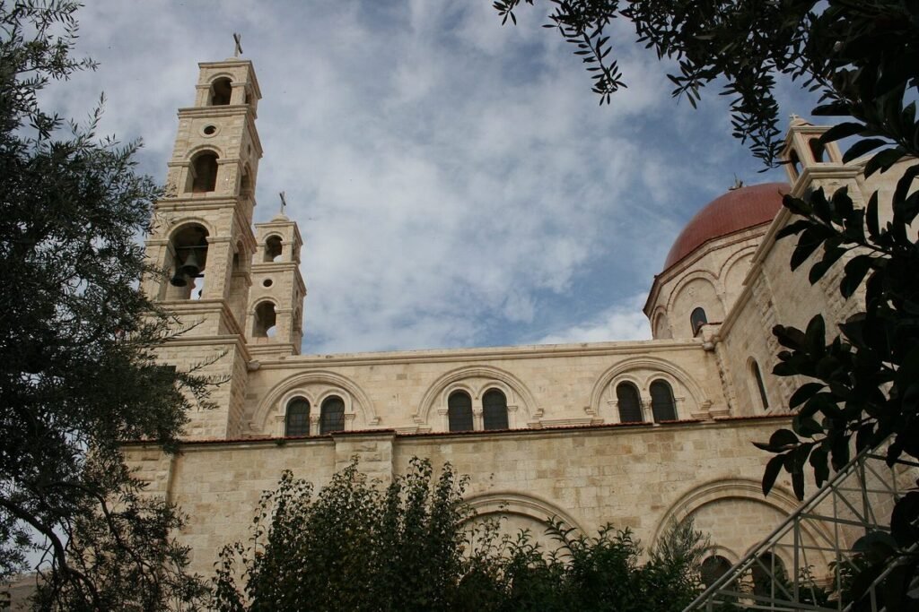 Church with bell towers and a dome at Jacob's Well, seen through branches